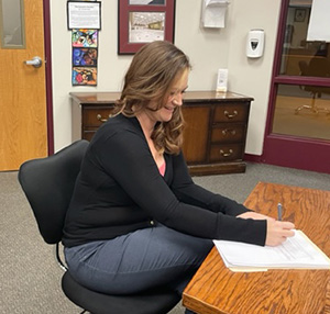Principal Allie Wheeler signing contract